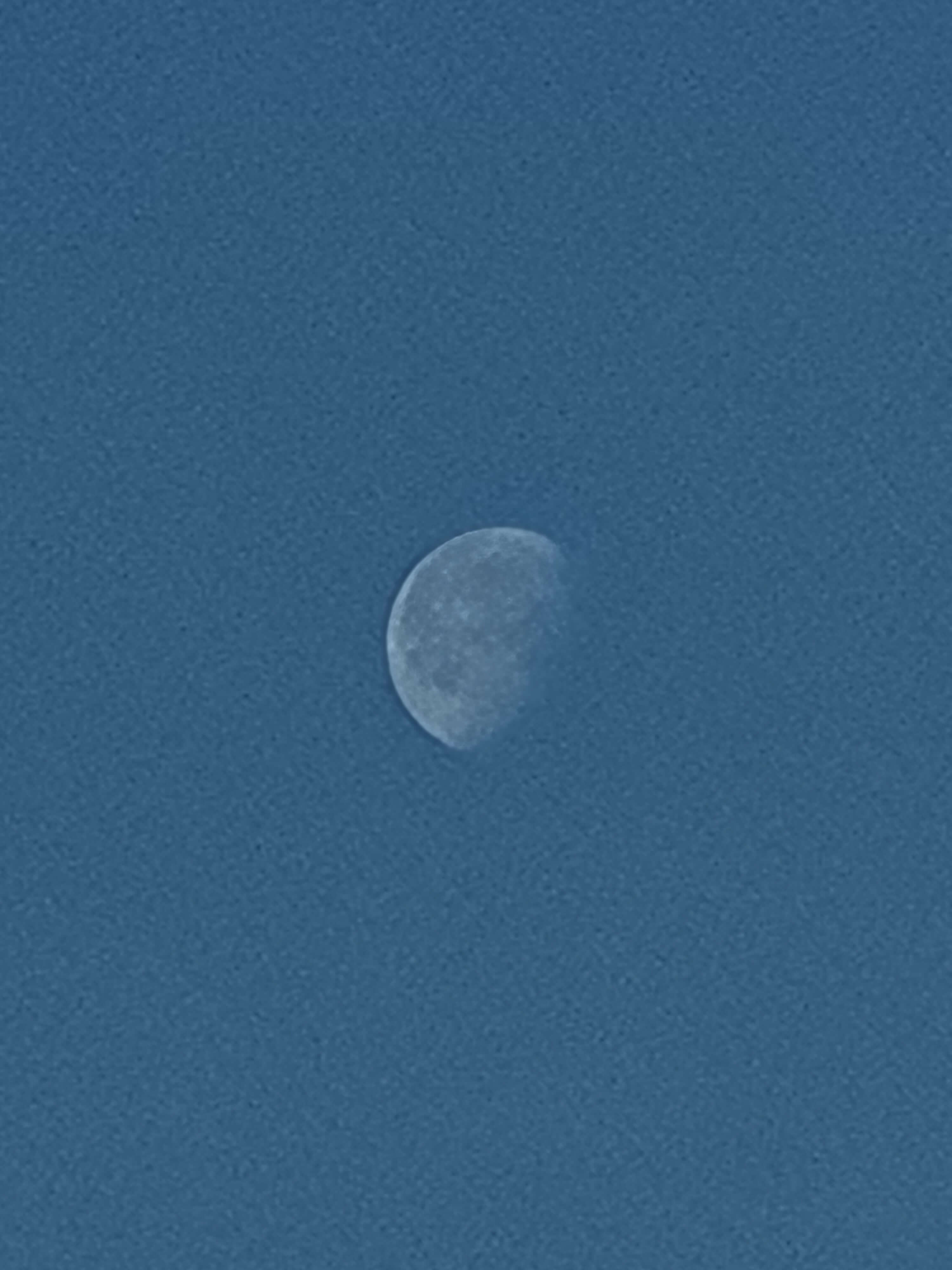 A very faint photo of the moon, which is not quite full.